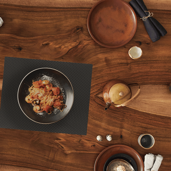 food entree on top of black counter mat on wooden table
