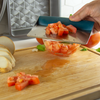 Taste of Home Bench Scraper with Sea Green handle, angled view on cutting board, lifting tomatoes,  lifestyle background