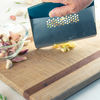 Taste of Home Bench Scraper with Sea Green handle, angled view on cutting board, close up chopping garlic, lifestyle background