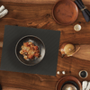 Food entree on top of black counter mat on wooden table 