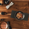 BLack matte counter mat on wooden table with assorted dishes