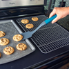 Taste of Home Nylon Turner featuring Ash Gray head and Sea Green handle lifting cookie off Taste of Home Baking Sheet