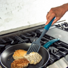 Taste of Home Nylon Slotted Turner with Ash Gray head, Sea Green handle, top view turning browned food in pan, lifestyle background