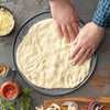 preparing pizza dough on pizza pan